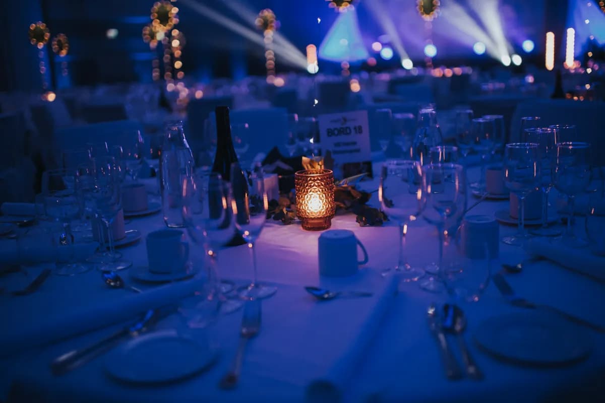 Elegant borddekning med stearinlys og glass klar for firmafest i Stavanger