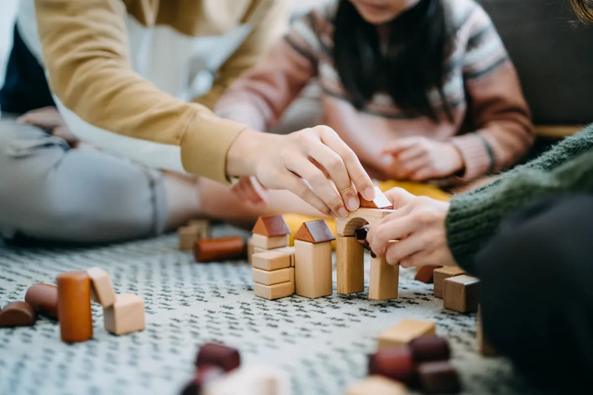 Team samarbeider om å bygge med treklosser under kreativ teambuilding-aktivitet