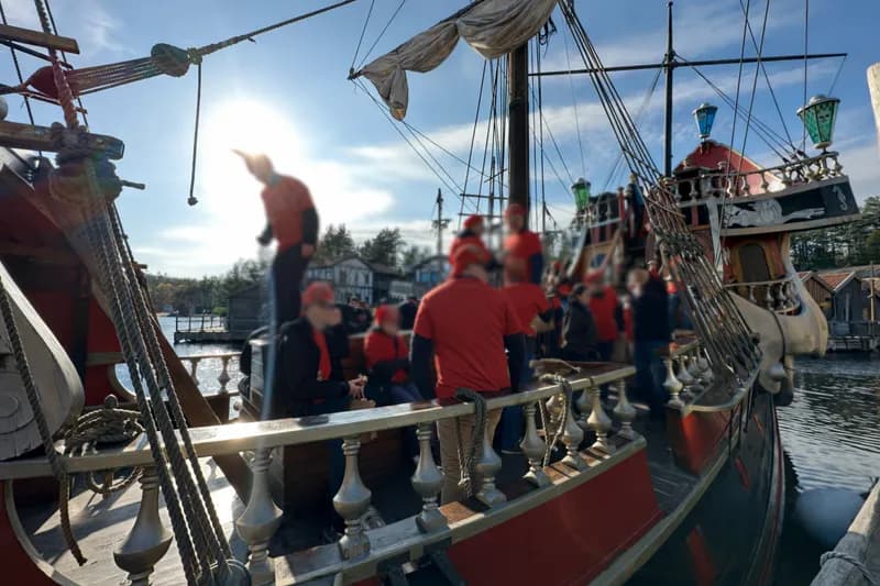 Teambuilding-aktivitet på sjøen med gruppe i røde drakter på historisk seilskip i Stavanger