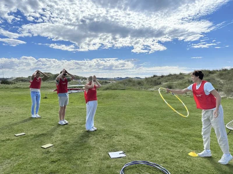 OL-leker teambuilding utendørs med ringkasting på grønt felt i Stavanger